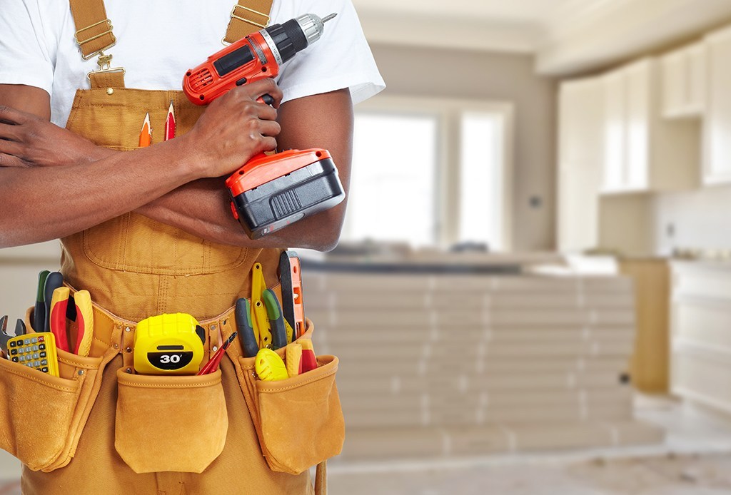 a skilled handyman holding various tools